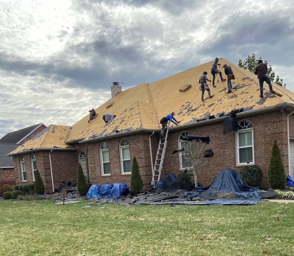 Rascon Roofing crew of workers tearing off and re-decking a large brick house roof
