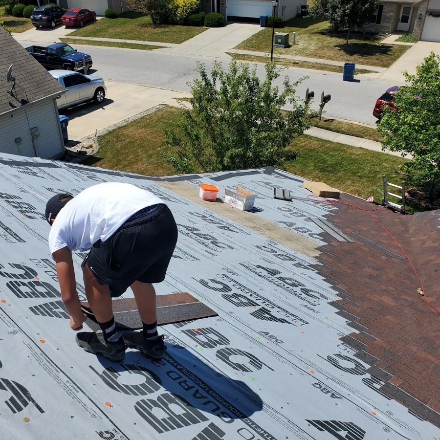 Technician installing synthetic underlayment and shingles